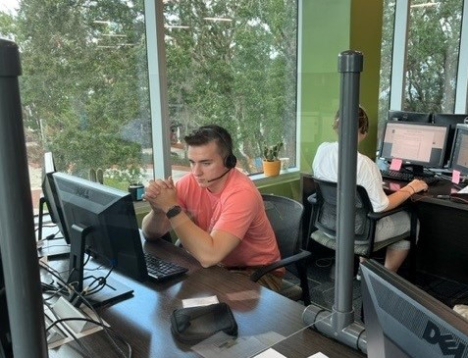 student with coral shirt using computer